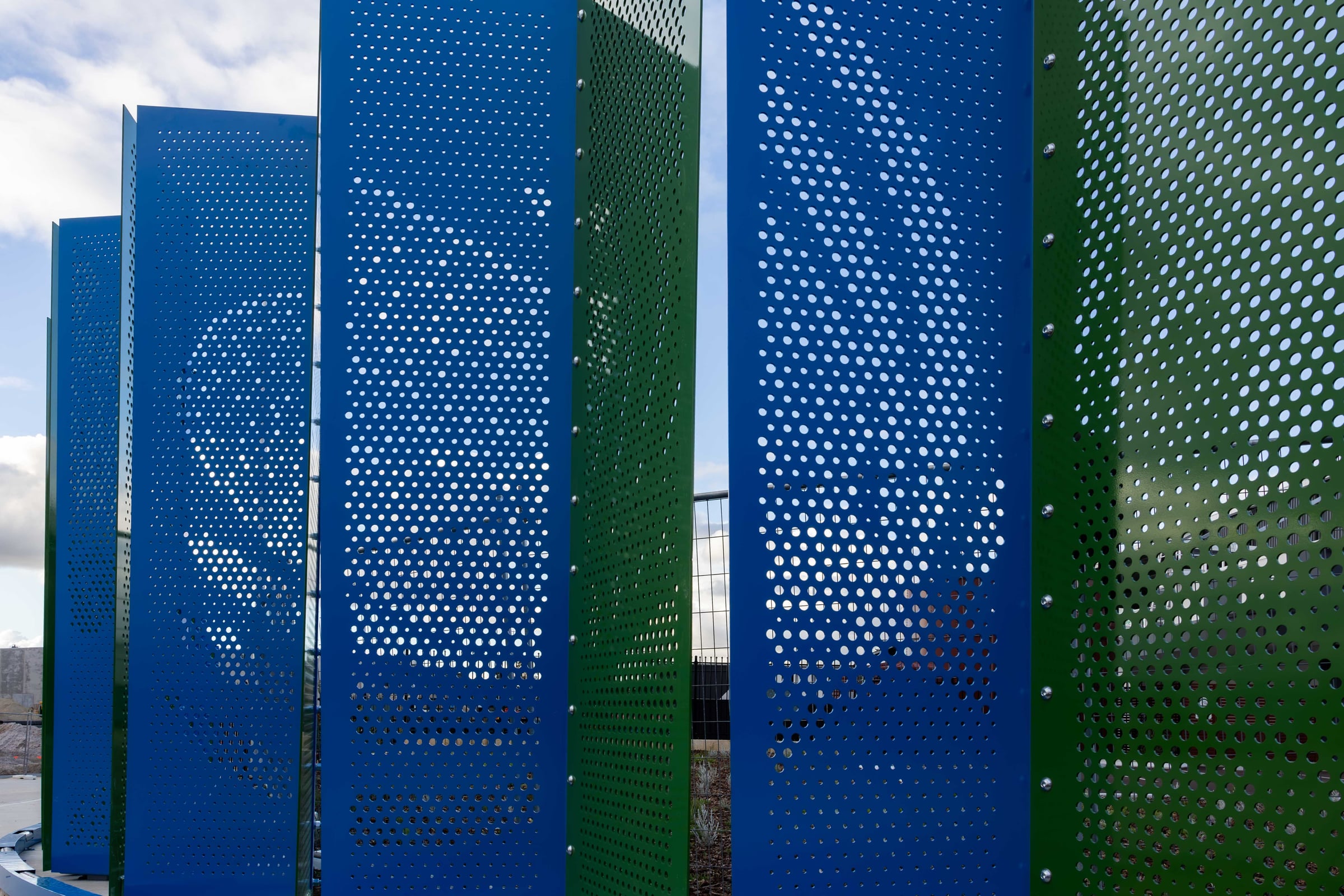 Close-up between pleats, where sky shows through the perforated steel of Duality.