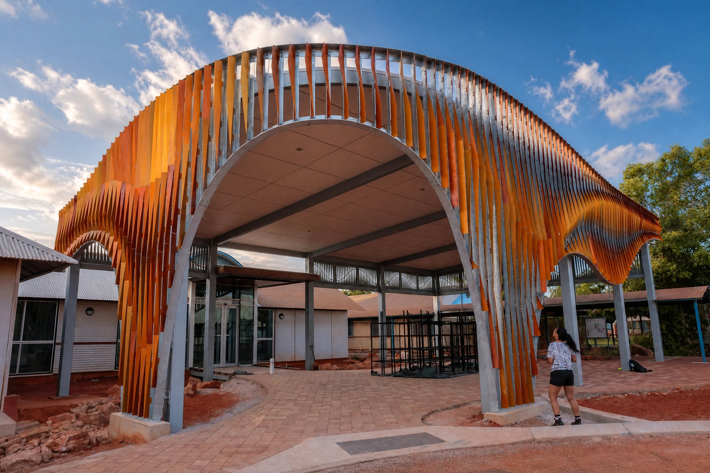 A visitor looks up into the great arch of Pleated Histories at Broome North Regional TAFE.