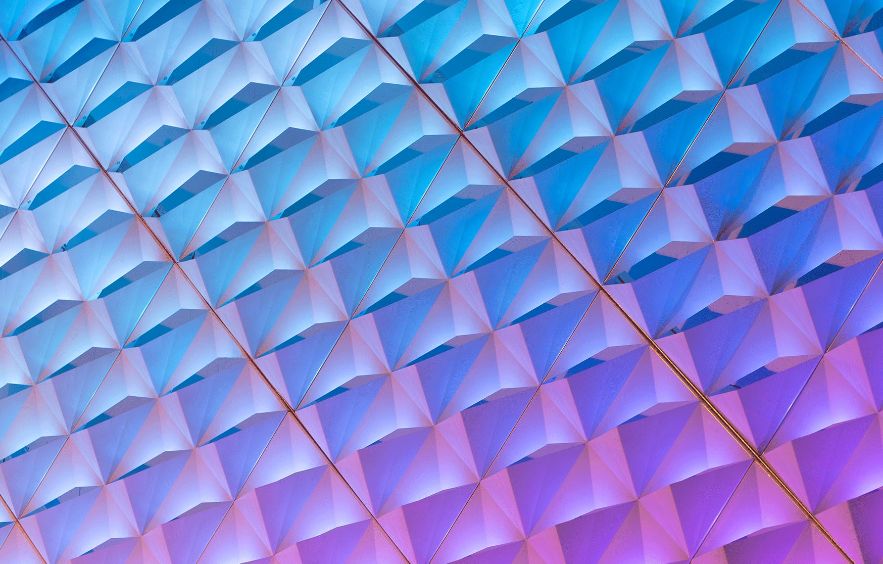 Close detail of pyramid folds in aluminium shifting from blue to magenta under LED light at The Precinct.